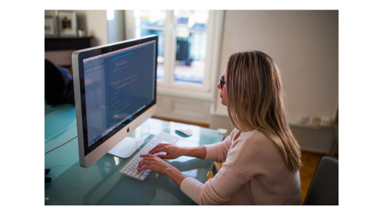 Person updating HTML code at a computer.